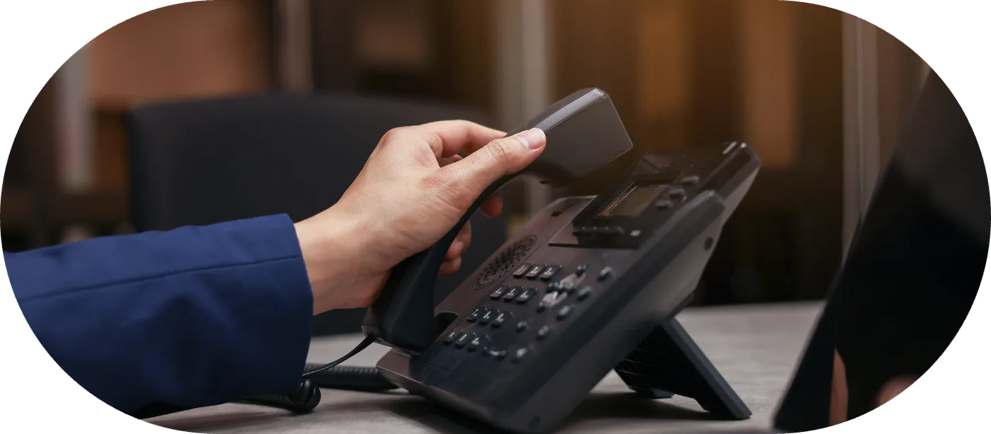 A desk handset in use at a workstation