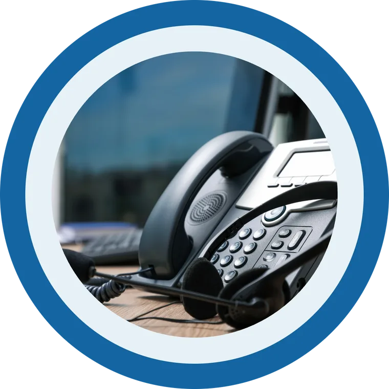 A desk phone and headset set up on a working desk